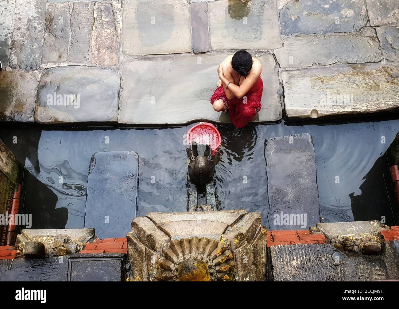 Kathmandu, Nepal. 23rd Aug, 2020. A woman bathsÂ atÂ a stone tap during the Rishi Panchami festival, as taking baths at riverÂ banks was prohibited by government due to concern of COVID-19 outbreak in Kathmandu, Nepal on August 23, 2020. Rishi Panchami festival marks the end of the three-day Teej festival when women worship Sapta Rishi (Seven Saints), take holy bathsÂ atÂ riverÂ banks and pray for health for their husband while unmarried women wish for a handsome husband and happy conjugal lives. Credit: Sunil Sharma/ZUMA Wire/Alamy Live News Stock Photo