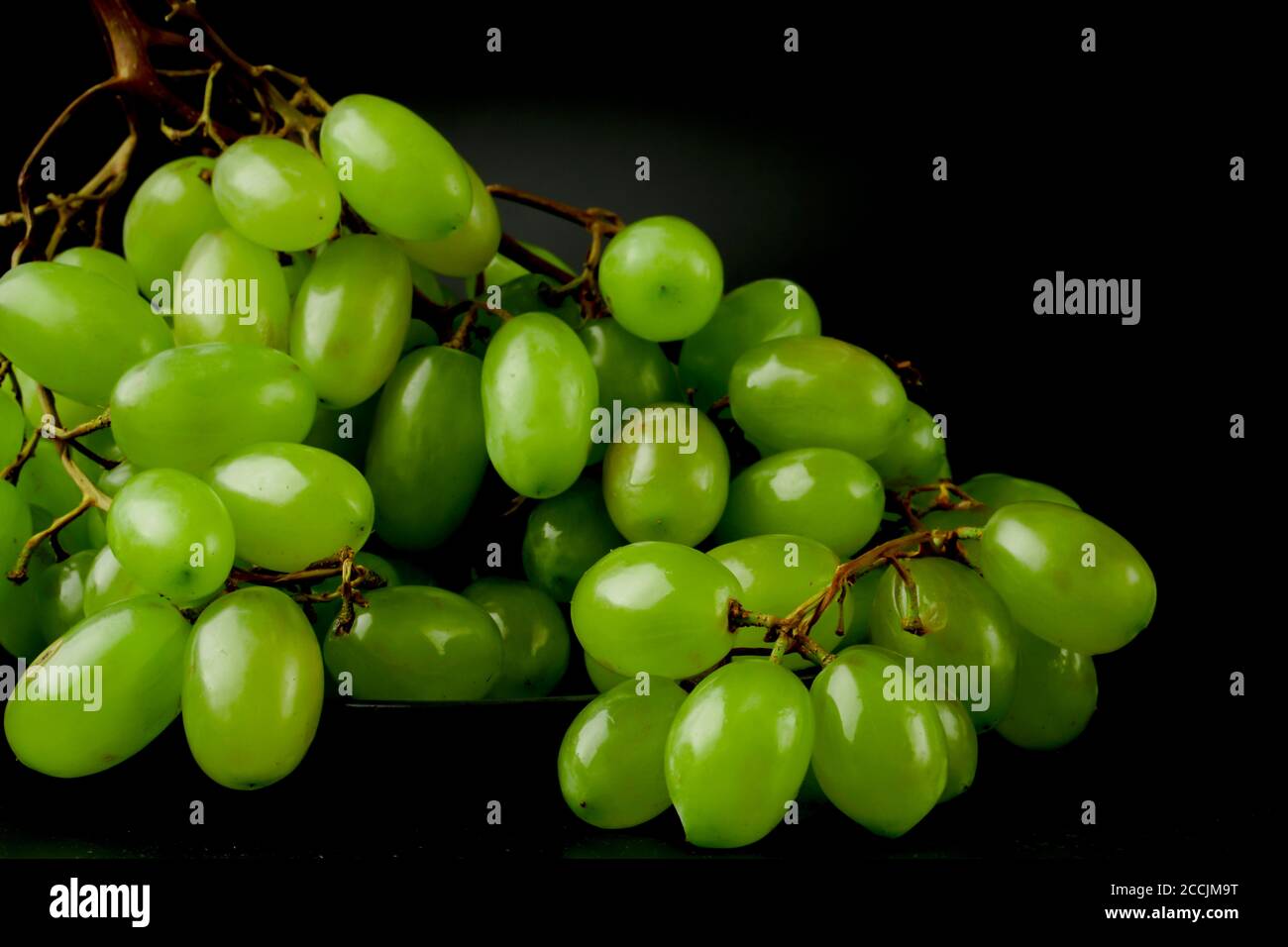 A bunch of table grapes on a black background Stock Photo Alamy