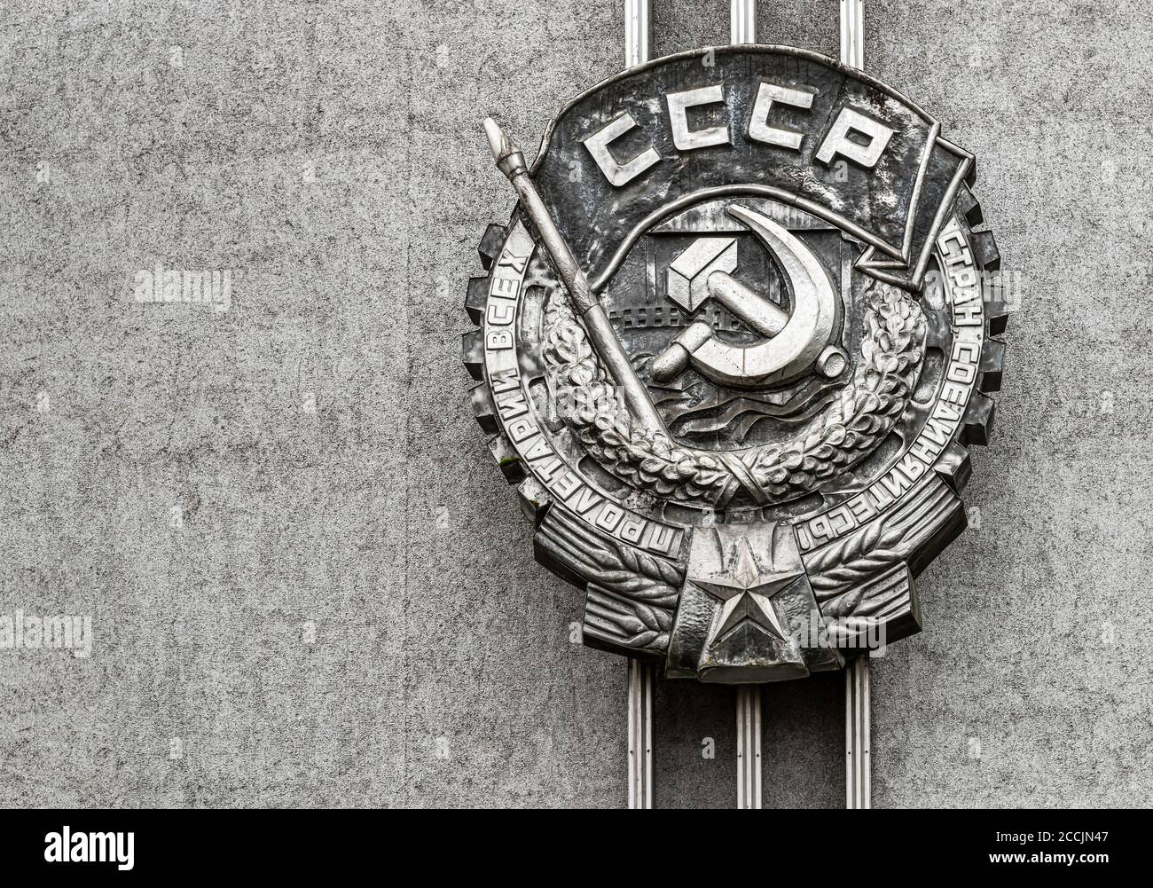 Emblem of the Soviet Union, sickle and hammer Soviet Union nation symbol on the stone wall. Stock Photo