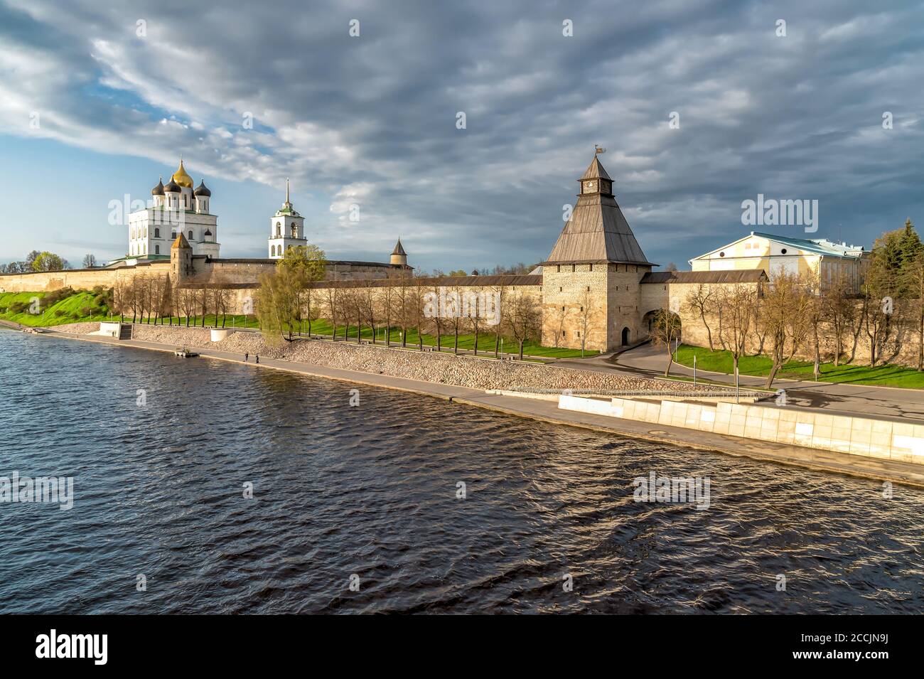 View of the Pskov Kremlin Krom on the Velikaya River with sunlight at sunset, Russia Stock Photo