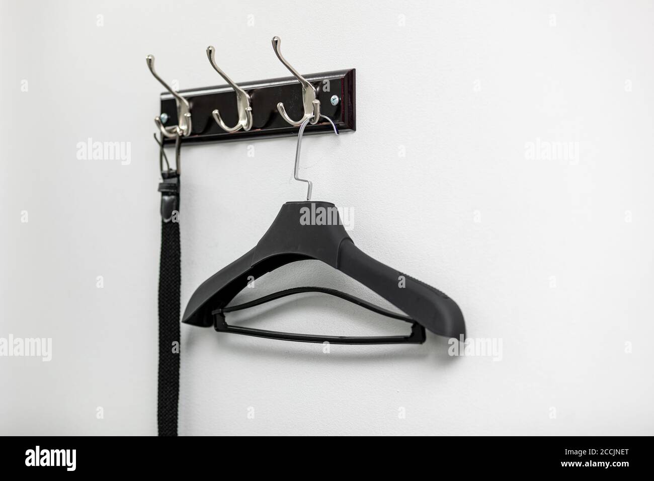 Male leather belt on hanger on hooks Stock Photo Alamy