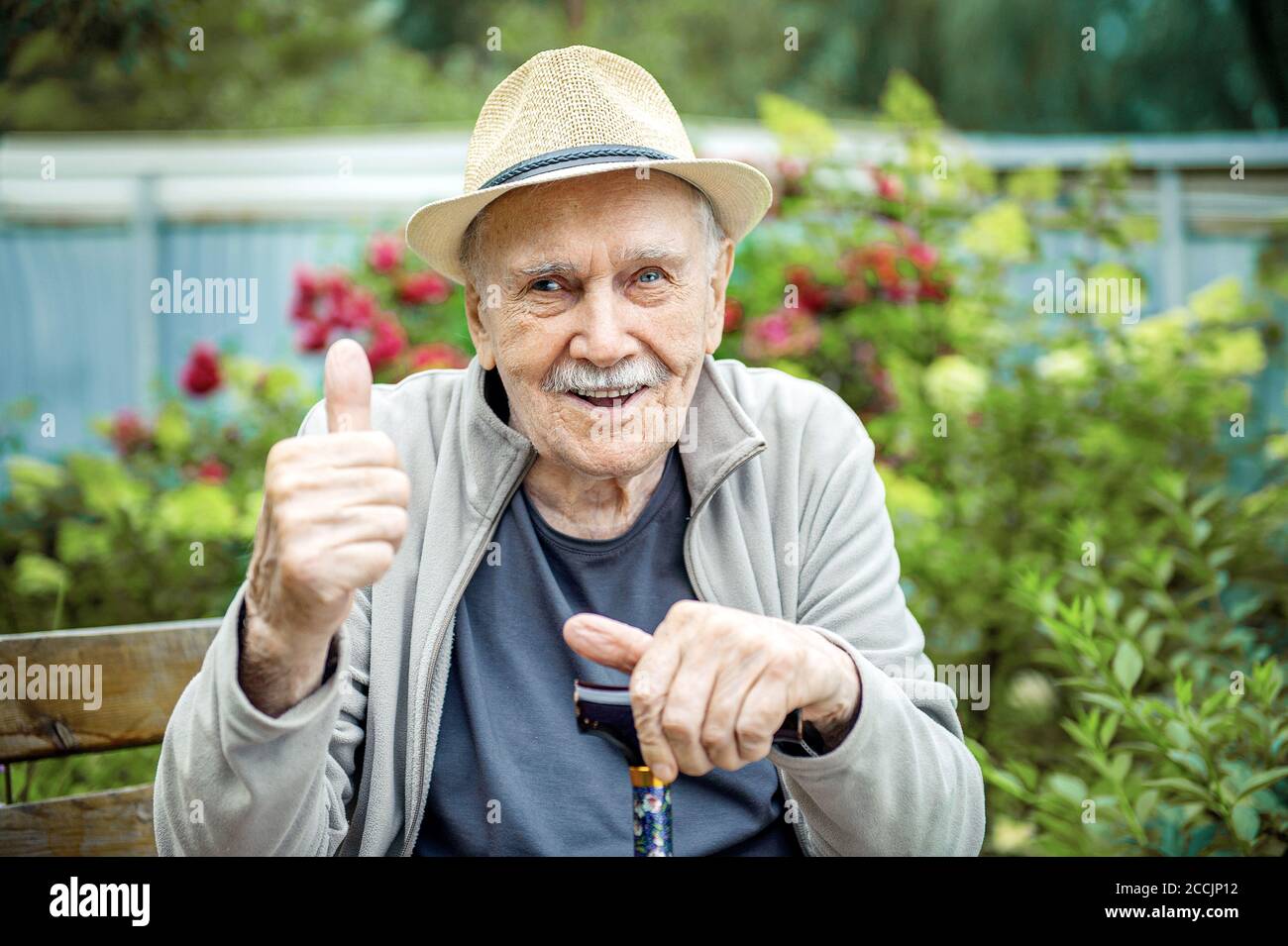 Portrait of a smiling and confident senior 87 years old cute in a hat with a mustache. Happy active old age Stock Photo