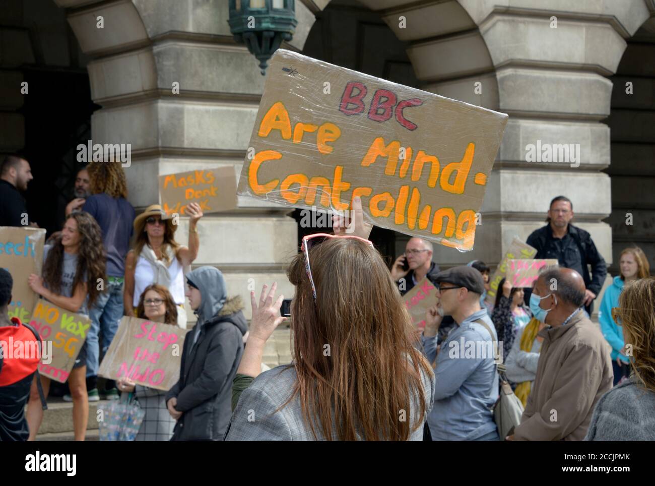 Woman with placard 'BBC are Mind Controlling' Stock Photo