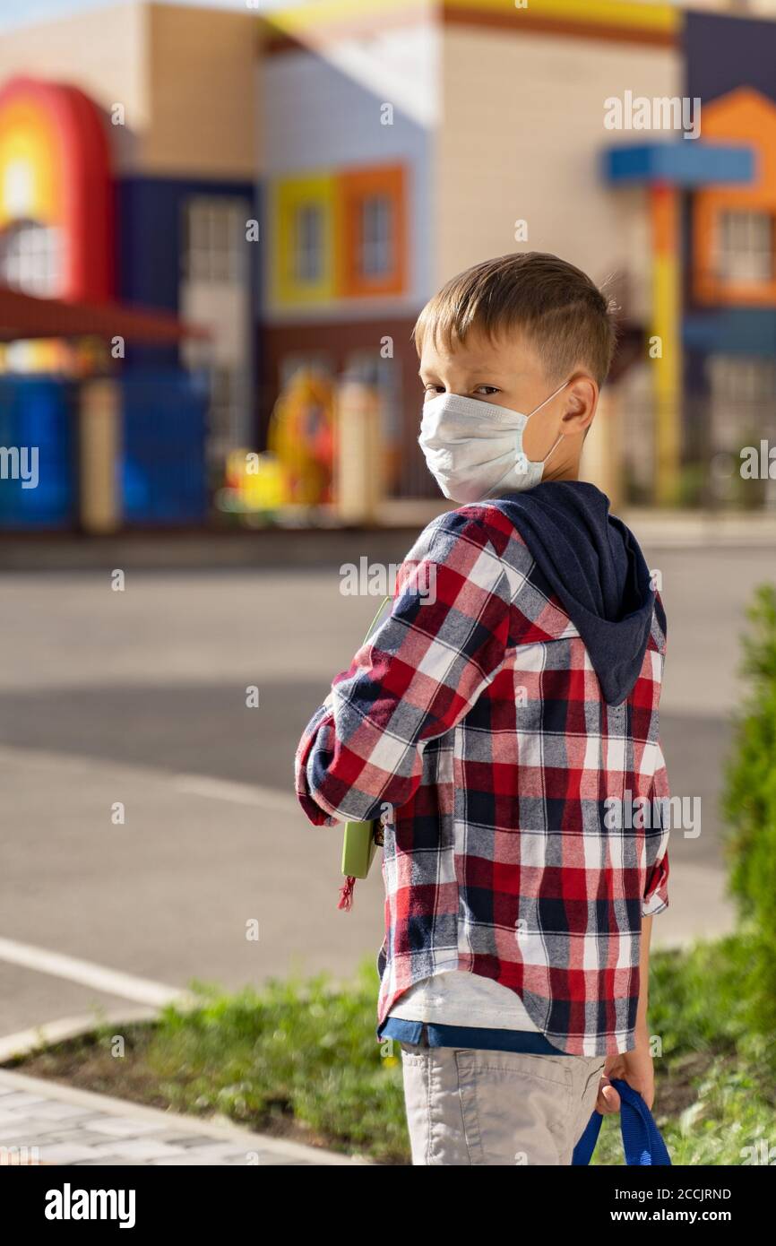 a small schoolboy in a medical mask goes to school Stock Photo