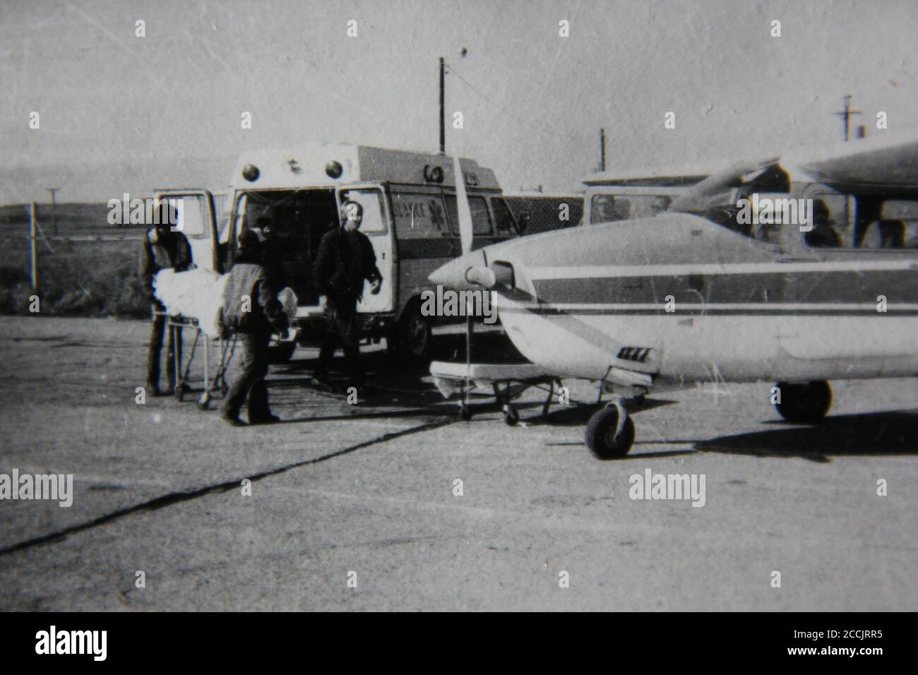 Fine 1970s vintage black and white photography of an ambulance meeting a plane at the airport. Stock Photo