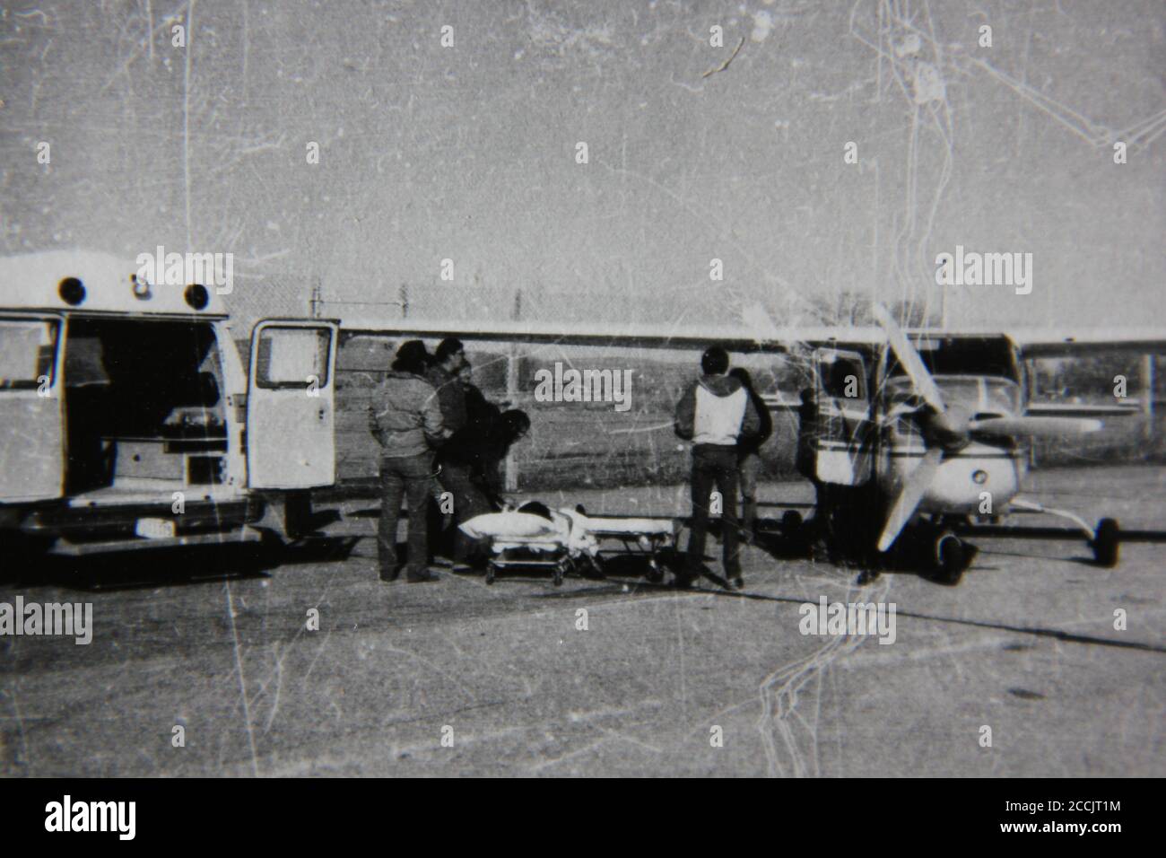 Fine 1970s vintage black and white photography of an ambulance meeting a plane at the airport. Stock Photo