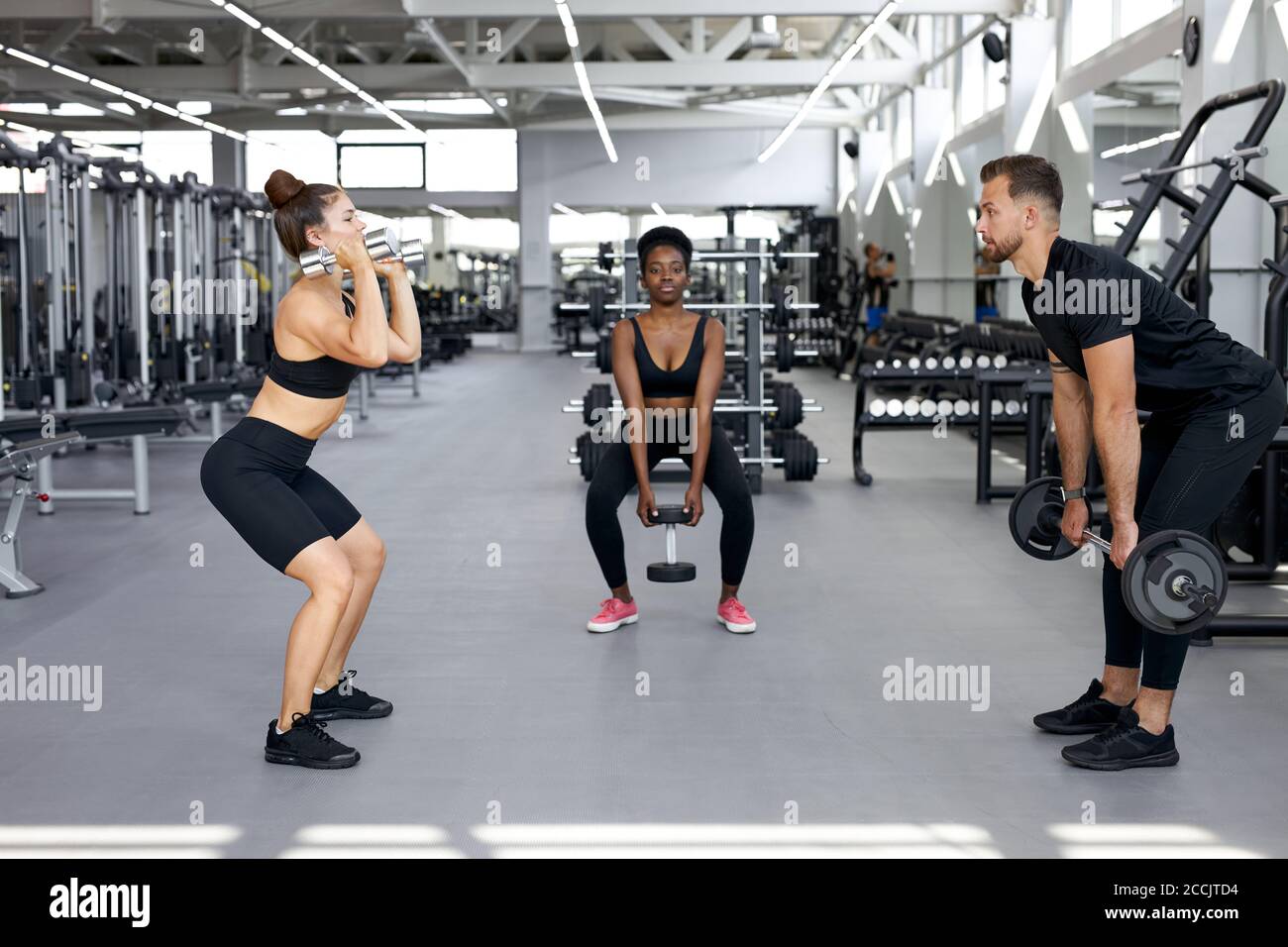 sportive people, multiethnic group perform exercises with heavy weights