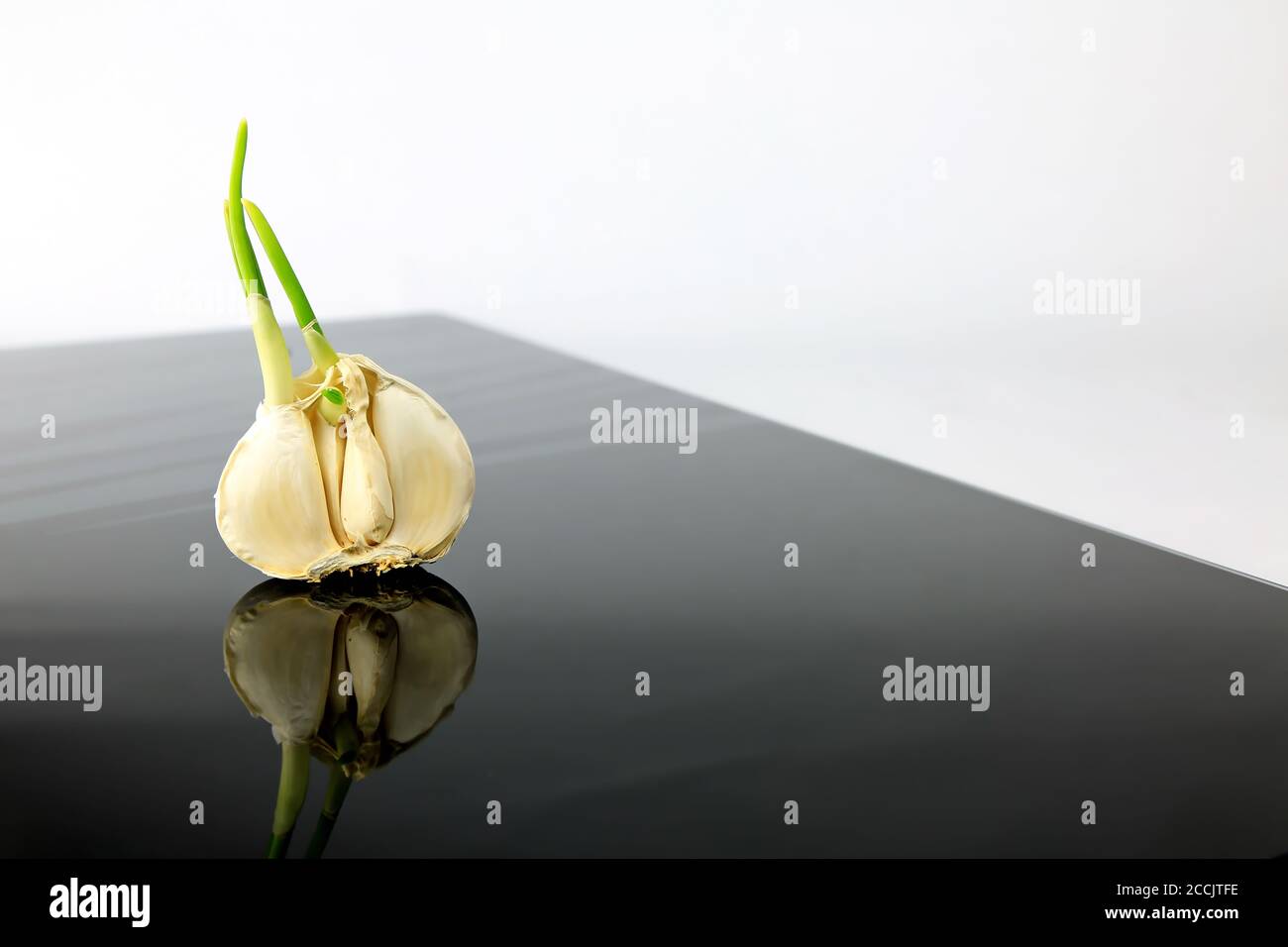 Garlic on a black plate wanders across the picture Stock Photo