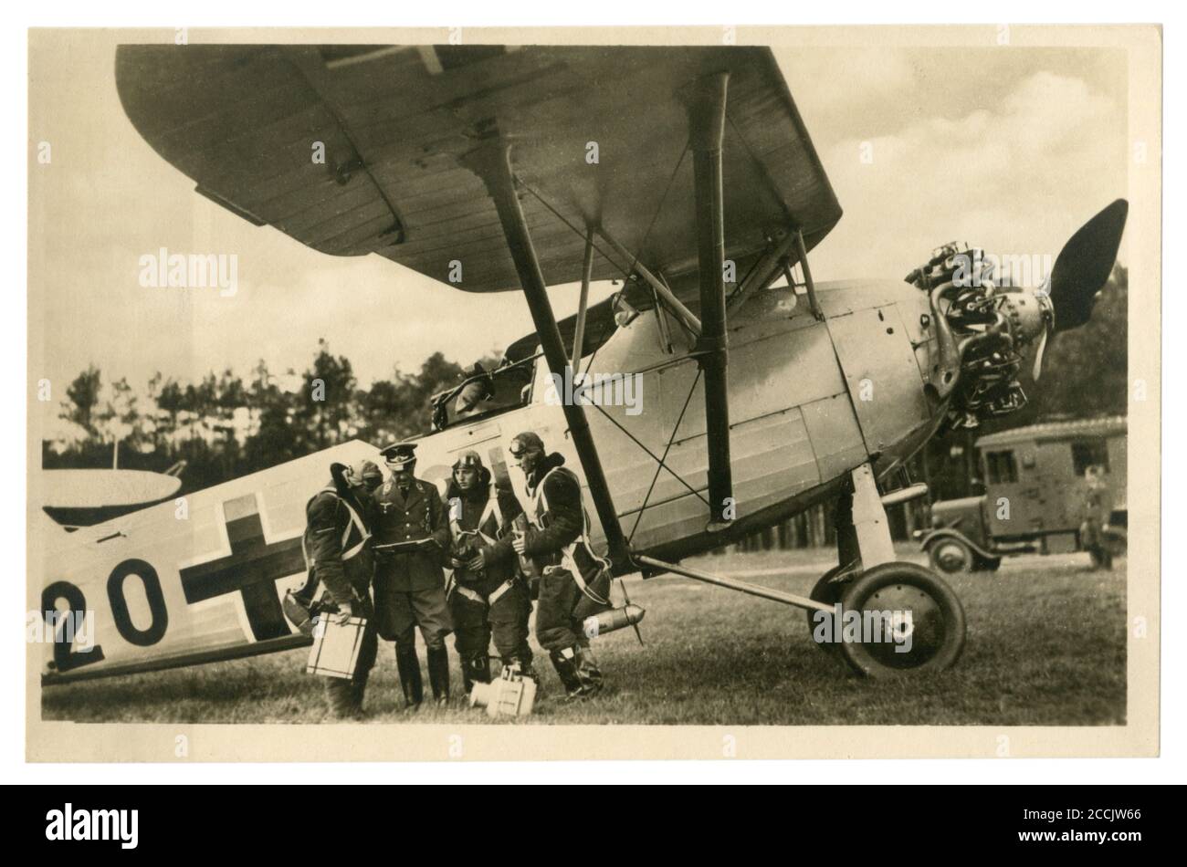 German historical photo postcard: the crew of a reconnaissance aircraft passes a pre-flight briefing at their aircraft, Germany, world war II Stock Photo