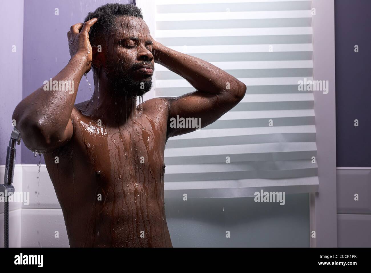 black man washing head with shampoo in shower, enjoy taking bath in the