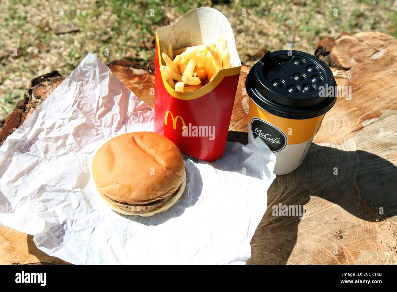 McDonald's Hamburger unwrapped, Large Fries and Hot Apple Pie, outside