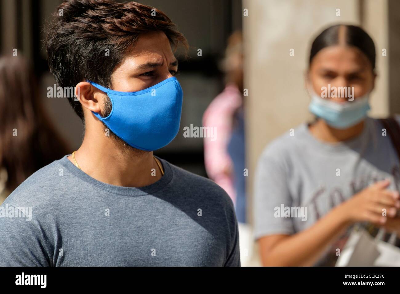 Young man  wearing fabric, reusable face covering on street, London, UK Stock Photo