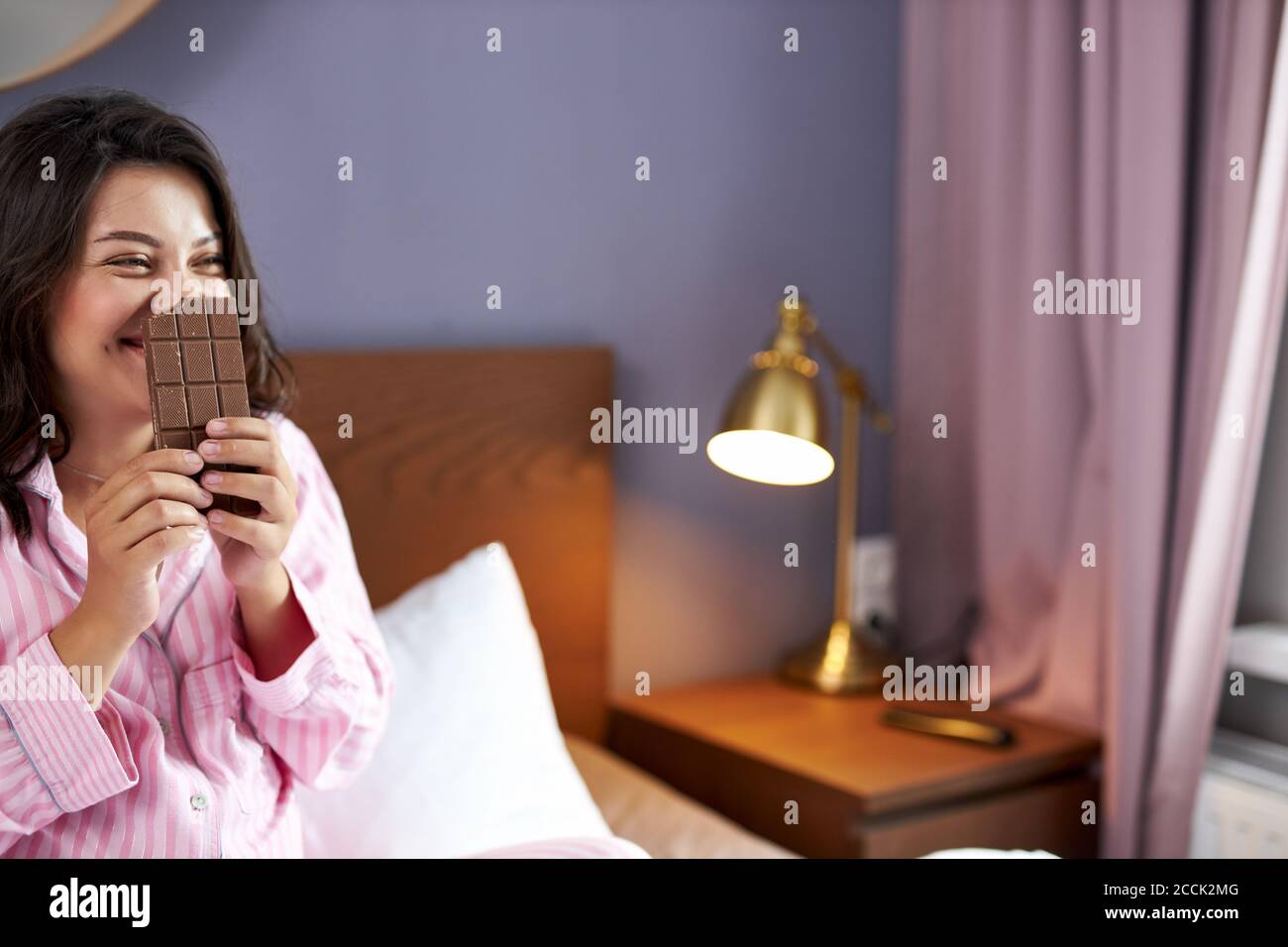 pregnant woman enjoys eating chocolate in bed at home,unhealthy sweet chocolate during pregnancy