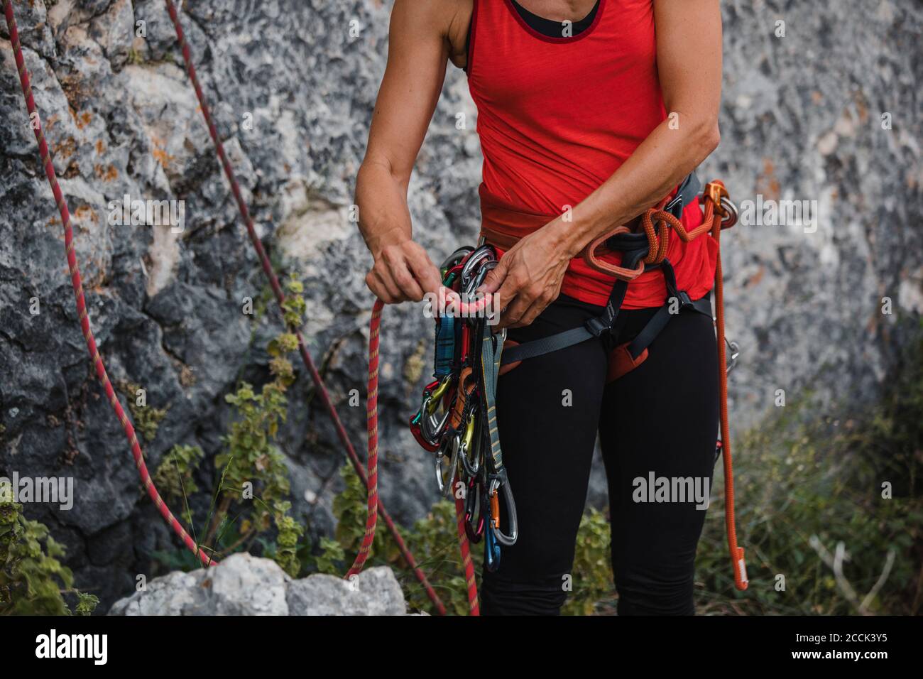 Woman adjusting ropes while preparing for rock climbing Stock Photo