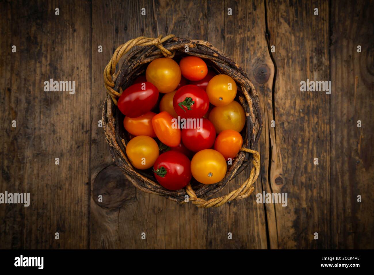 Tomatoes in wicker basket Stock Photo - Alamy