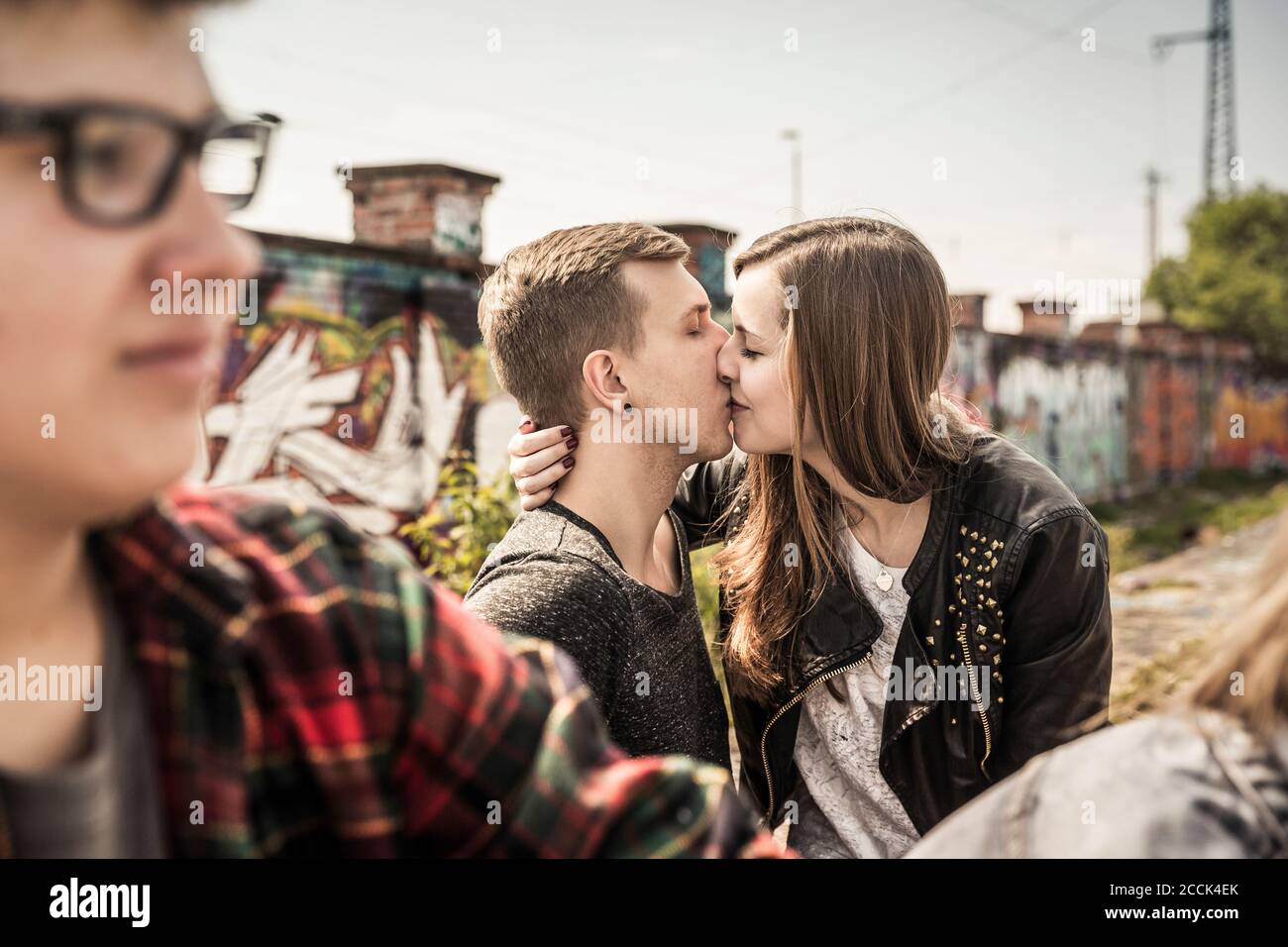 Teenage couple kissing in an old run down industrial area Stock Photo