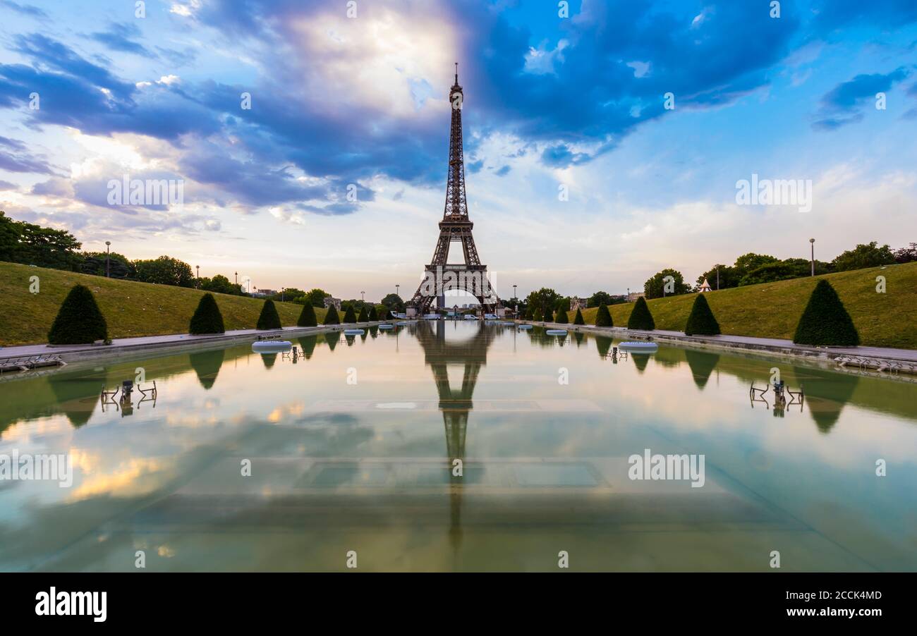 Eiffel Tower by Seine river against blue sky at sunset, Paris, France Stock Photo