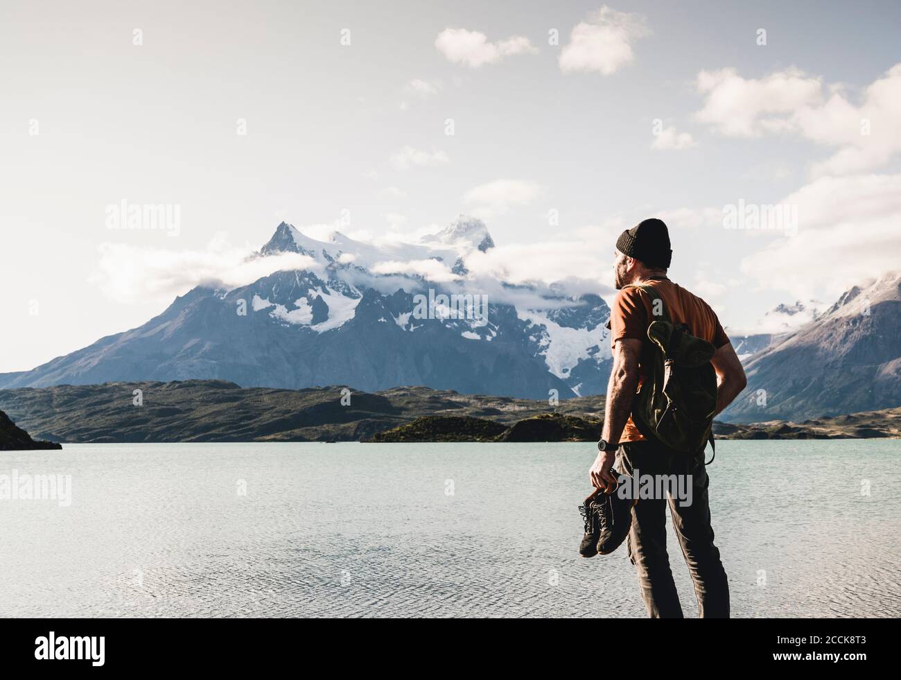 Man with shoes admiring view of lake Pehoe in Torres Del Paine National Park, Chile Patagonia, South America Stock Photo