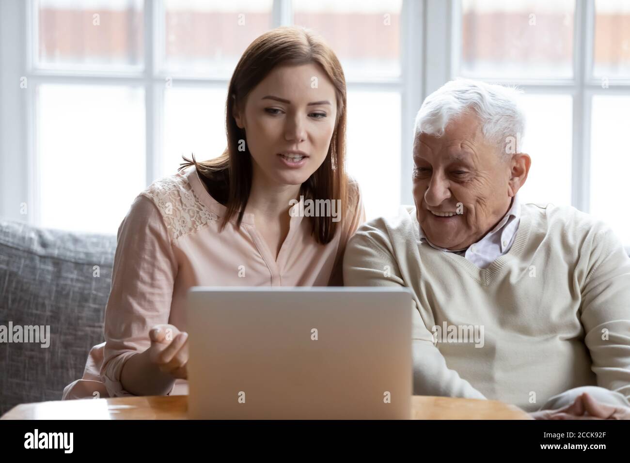 Happy 70s man learning using computer software with caring daughter ...