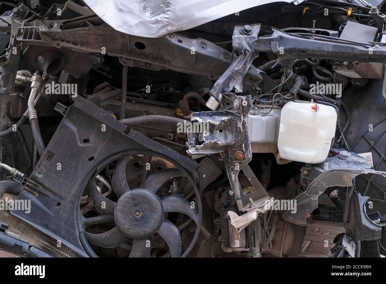 Car crush. Close-up front view of a wrecked car. Car after head-on collision. Bent hood and broken parts Stock Photo