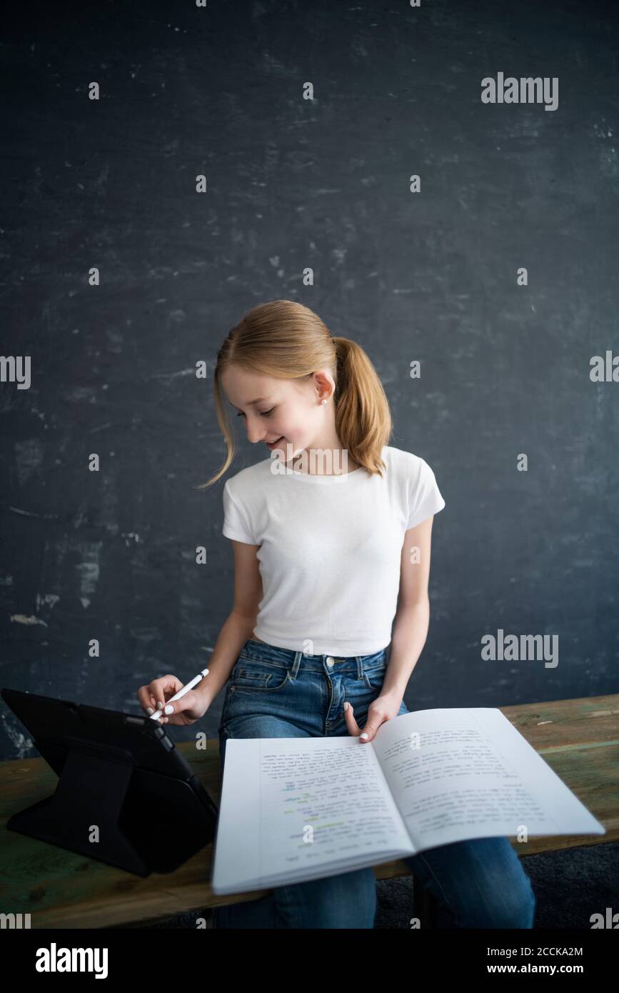 Blond girl learning and using tablet at home Stock Photo