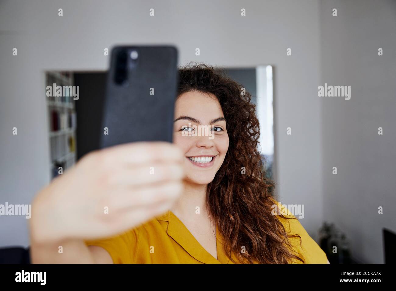 Happy young beautiful woman taking selfie at home Stock Photo - Alamy
