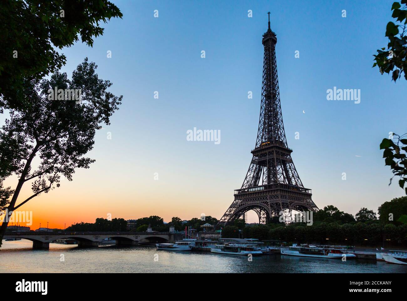 Eiffel Tower by seine river against clear sky at sunset, Paris, France Stock Photo
