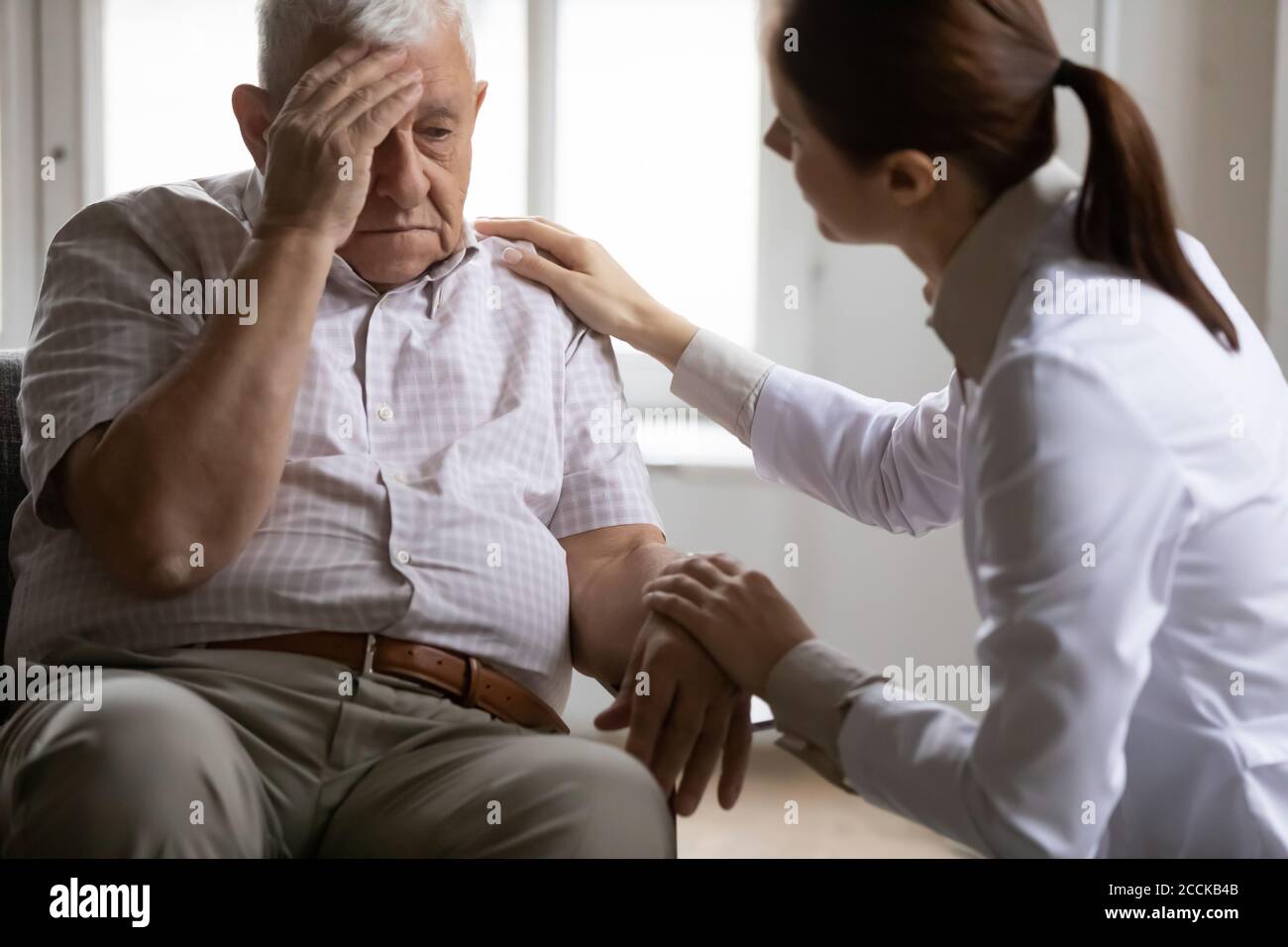 Unhealthy mature old patient complaining about head ache. Stock Photo