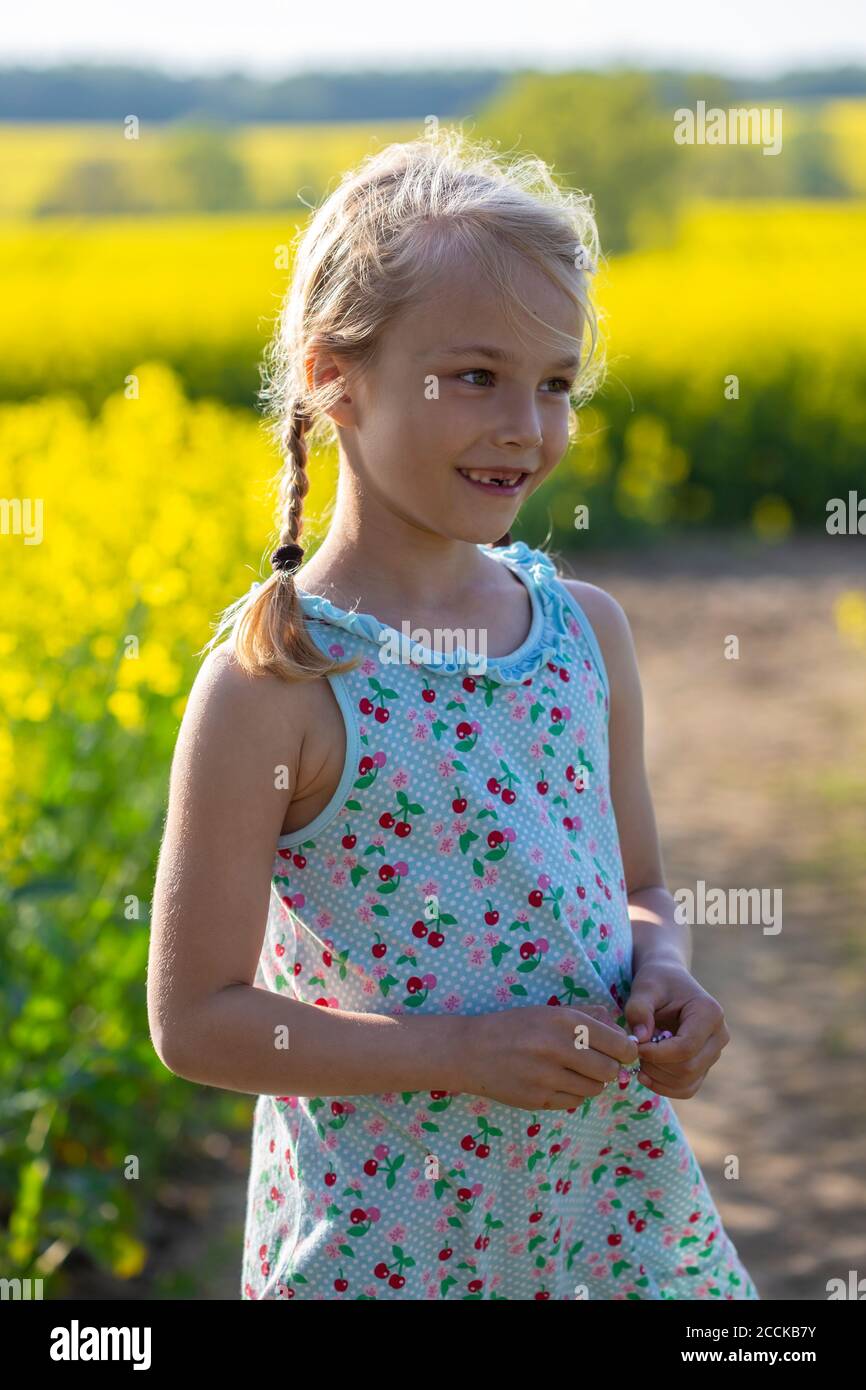 Cute little girl standing in farm of rapeseed field Stock Photo - Alamy