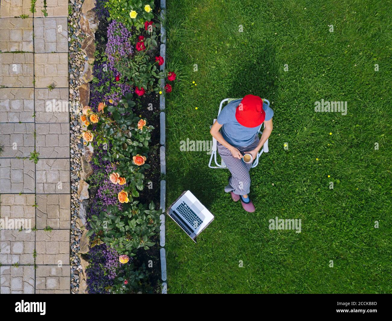 Woman sitting with laptop in garden Stock Photo