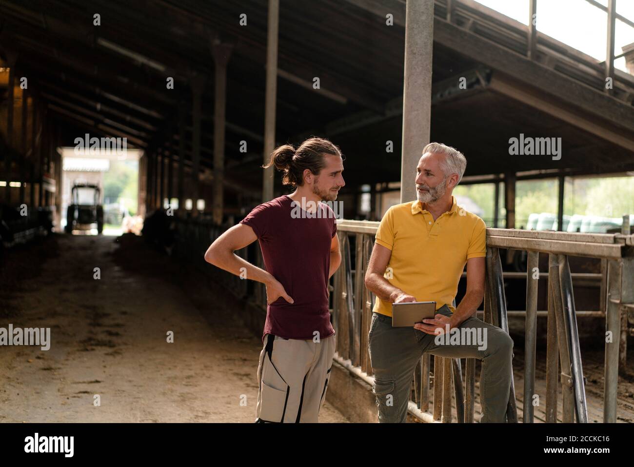 Mature farmer with tablet and adult son on a farm Stock Photo