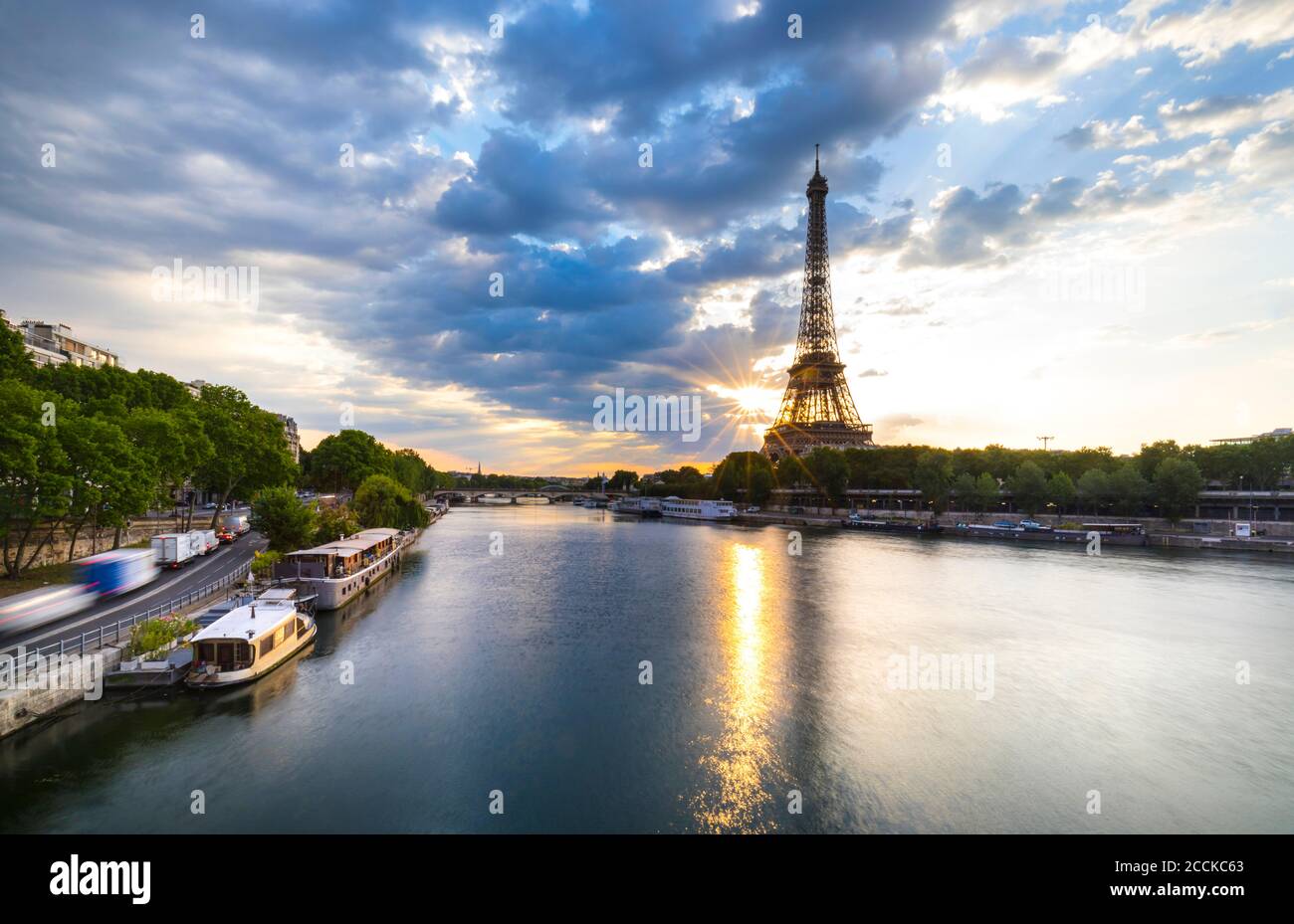 Eiffel Tower by Seine river against blue sky during sunrise, Paris, France Stock Photo