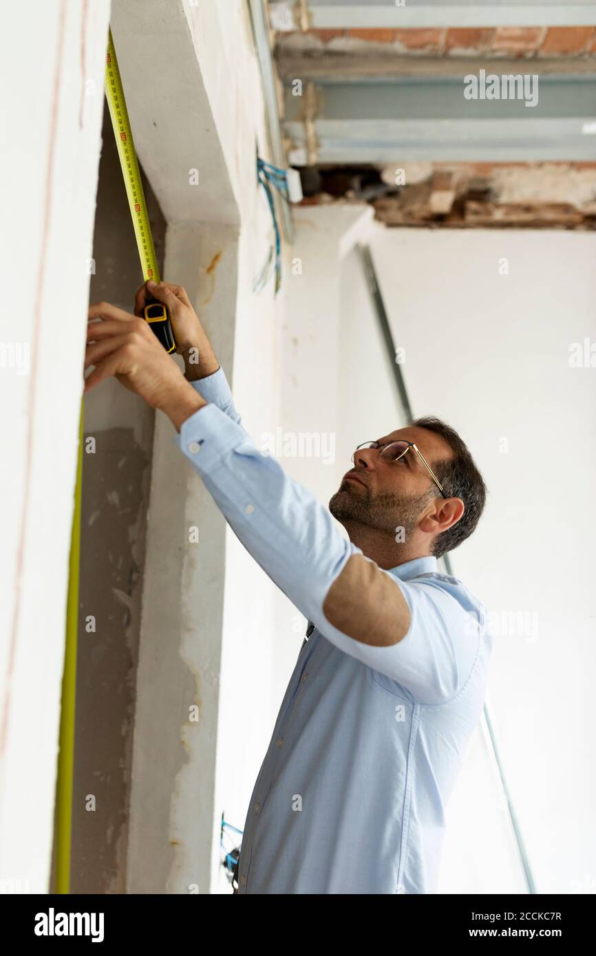 Builders Using Measure Architect using tape measure in a house under construction Stock Photo ...