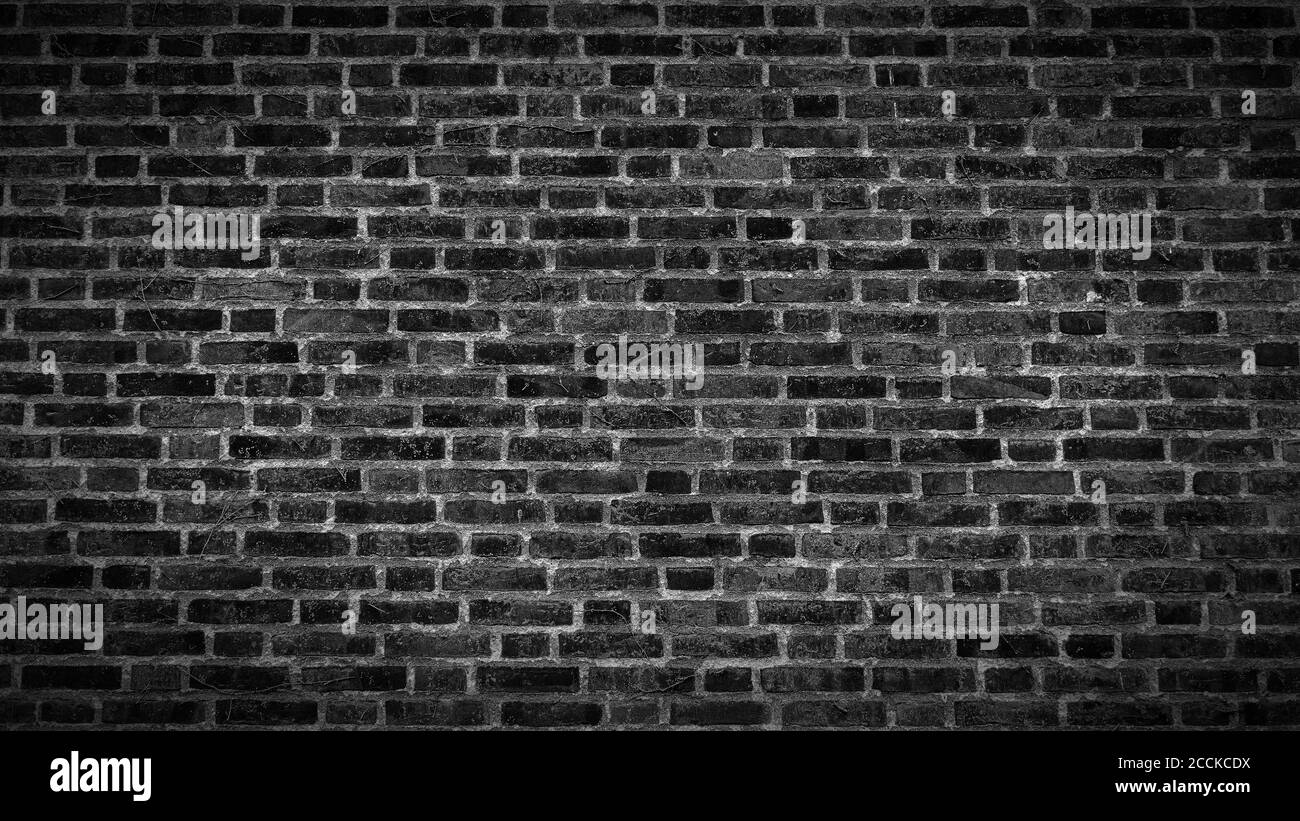 A panoramic view of an aged black brick wall texture with vignette ...