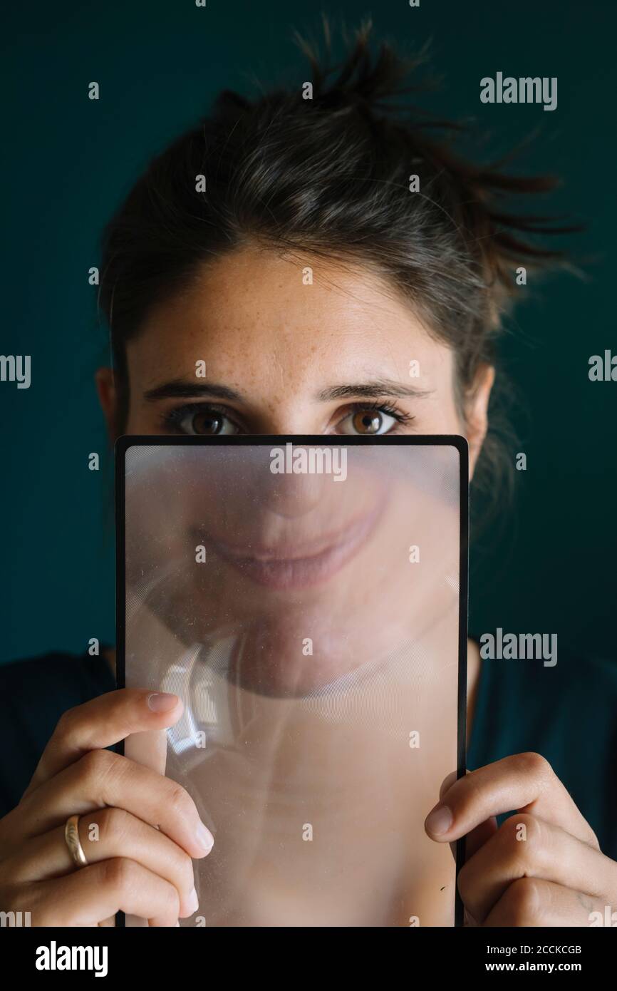 Young Woman Smiling Behind a Magnifying Glass Stock Photo - Alamy