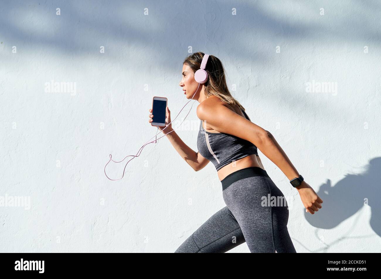 Woman listening to music while running in city Stock Photo Alamy