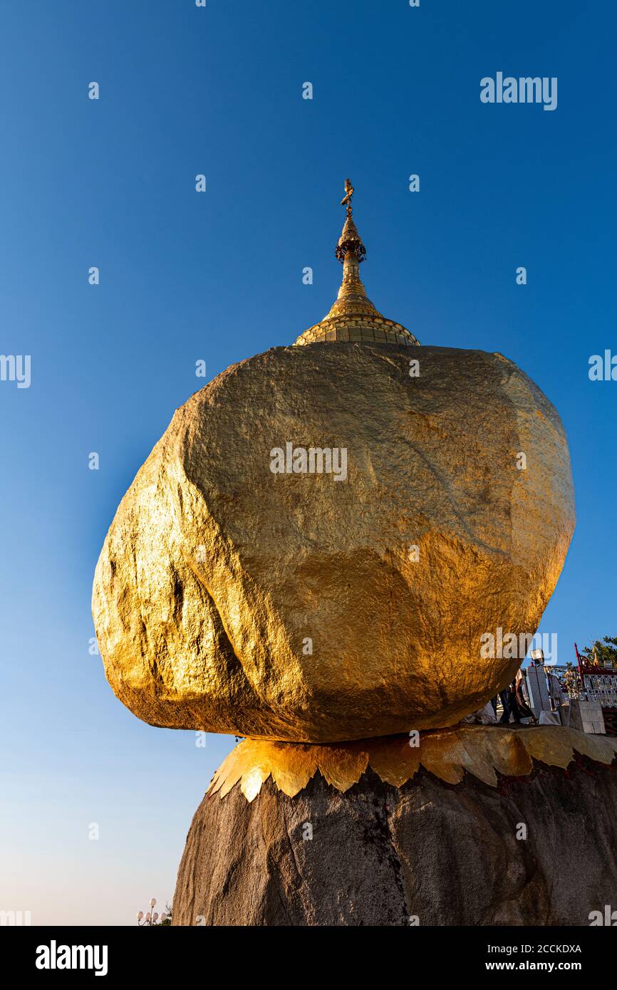 Myanmar, Mon state, Kyaiktiyo Pagoda, Golden rock against blue sky, low angle view Stock Photo