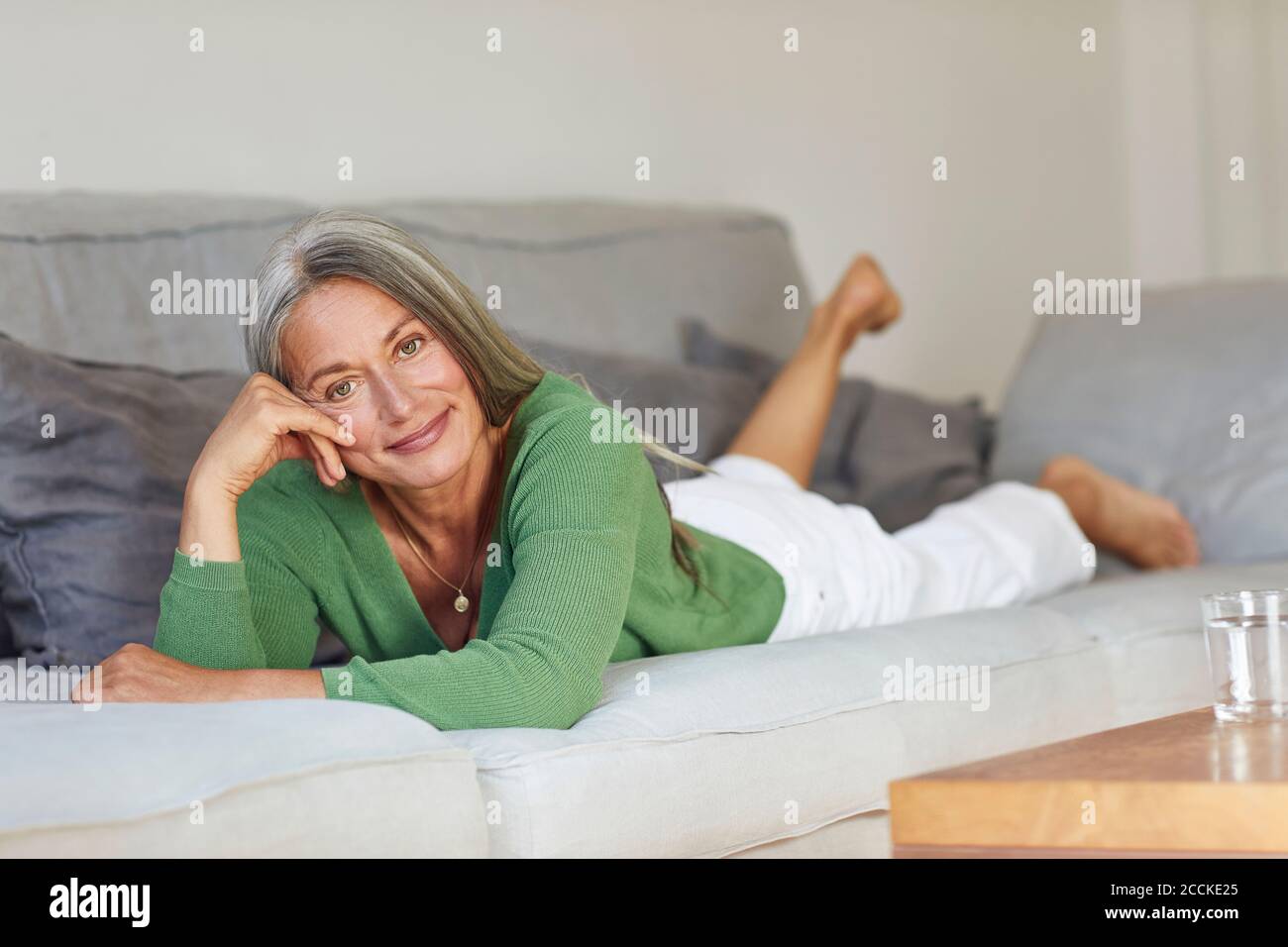 Beautiful mature woman on sofa hi-res stock photography and images - Alamy