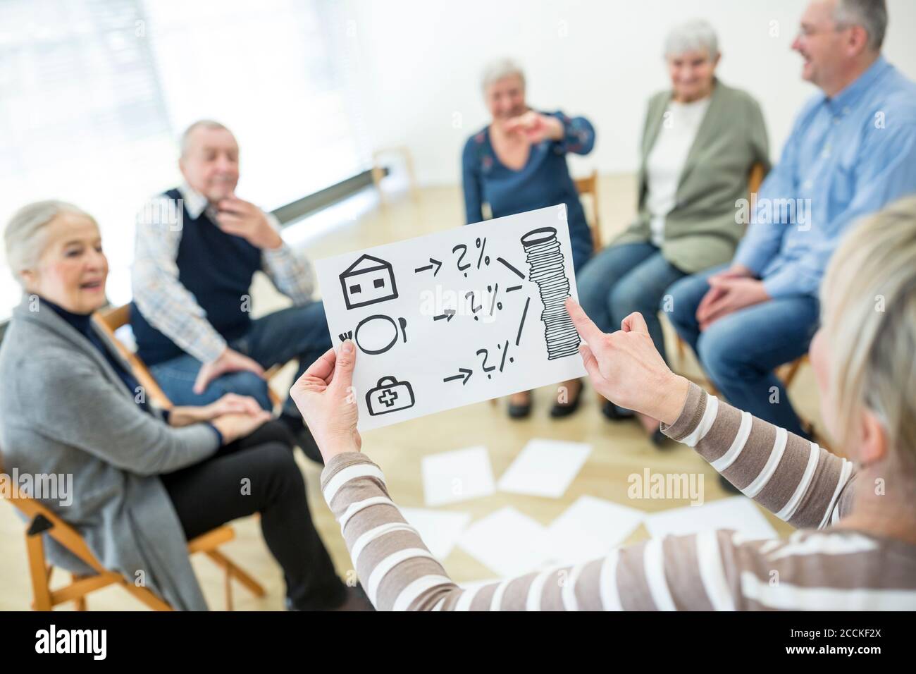 Person holding sheet with cost calculation for gereatric care in retirement home Stock Photo