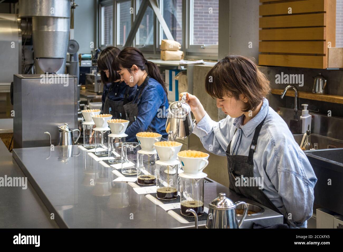 Tokyo, Japan - Baristas making hand drip, or pour over coffee in Blue Bottle Coffee Kiyosumi-Shirakawa Roastery and Cafe. Stock Photo