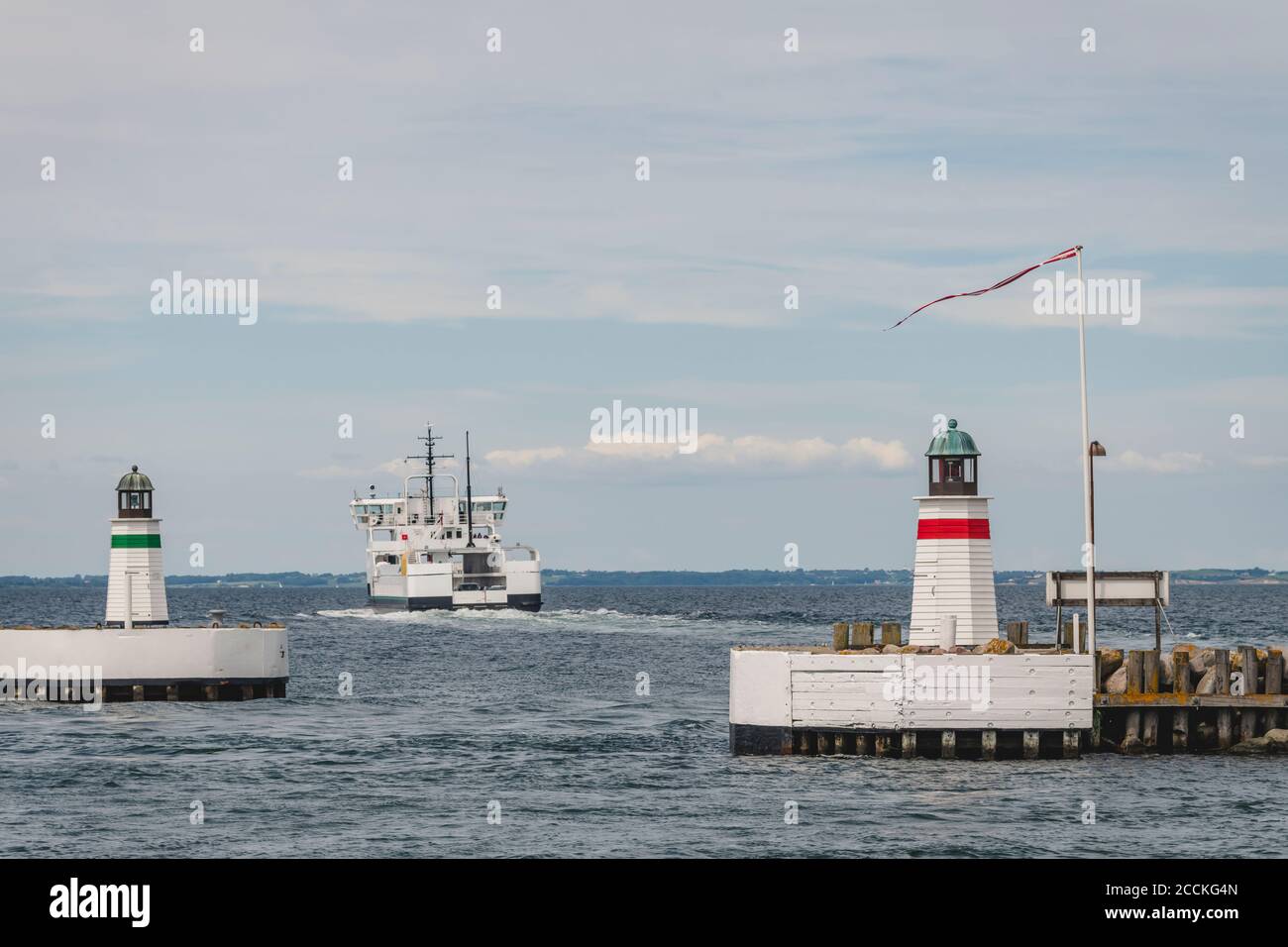 Denmark, Region of Southern Denmark, Soby, Two coastal lighthouses with ship sailing away in background Stock Photo