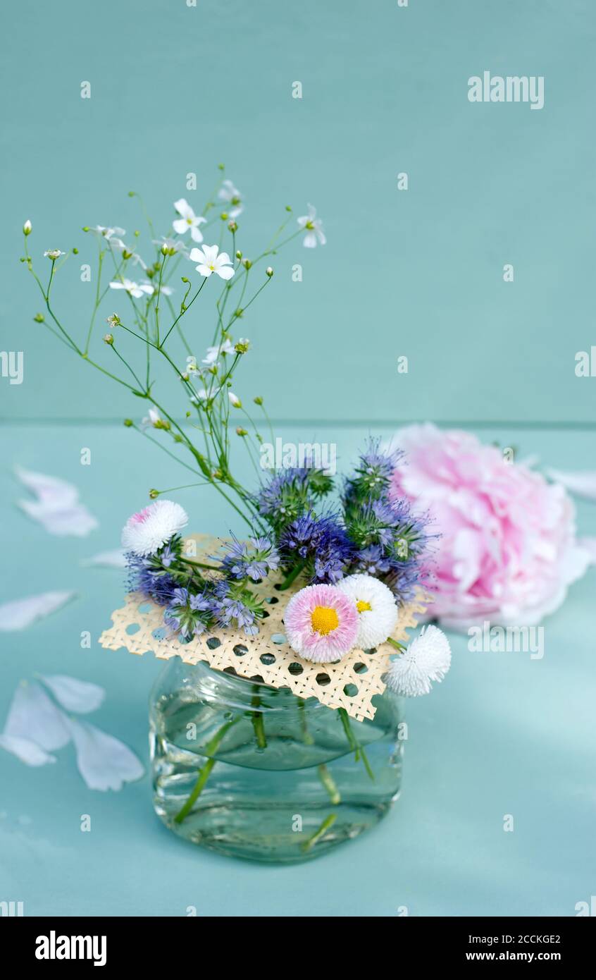 Various flowers in handmade jar with Viennese braid Stock Photo