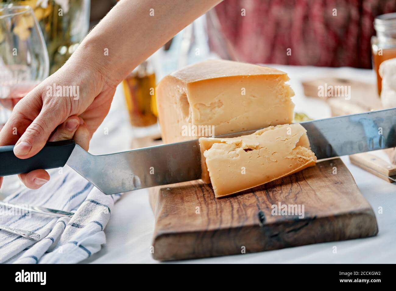 Hands cutting cheese on wood Stock Photo