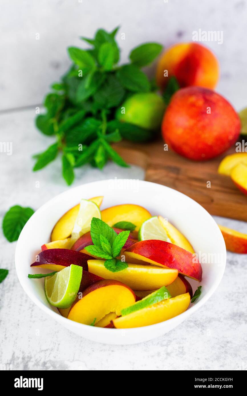 Fruit salad with peach, lime and mint Stock Photo