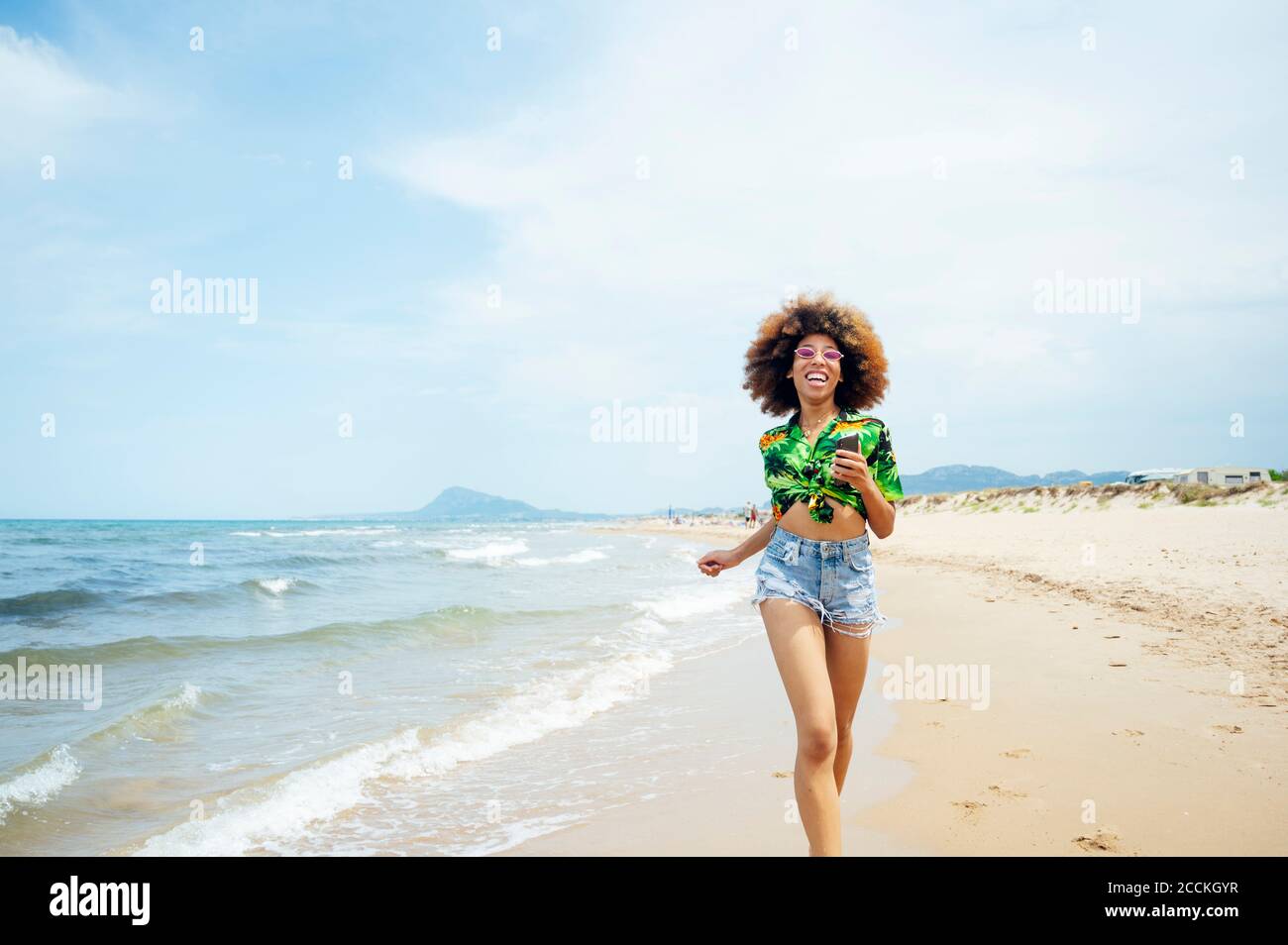 Young woman running at the beach Stock Photo