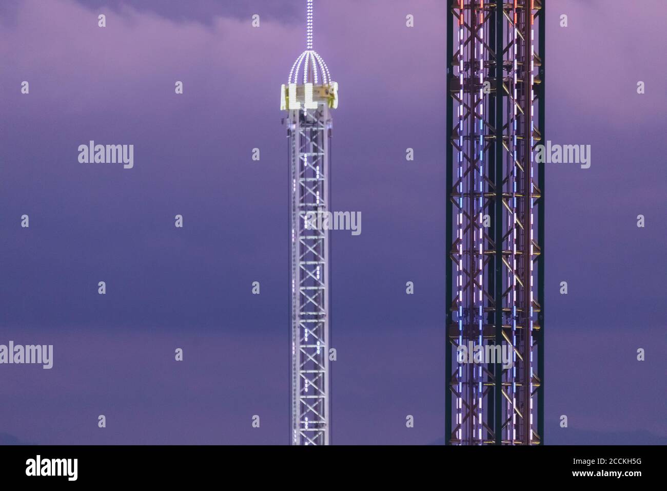 Germany, Bavaria, Munich, Drone view of free fall amusement park tower at dusk Stock Photo