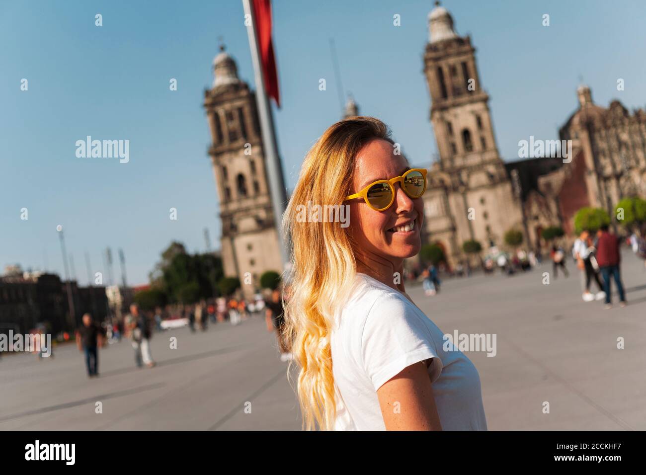 Smiling young woman wearing sunglasses while standing at Zocalo Square, Mexico Stock Photo