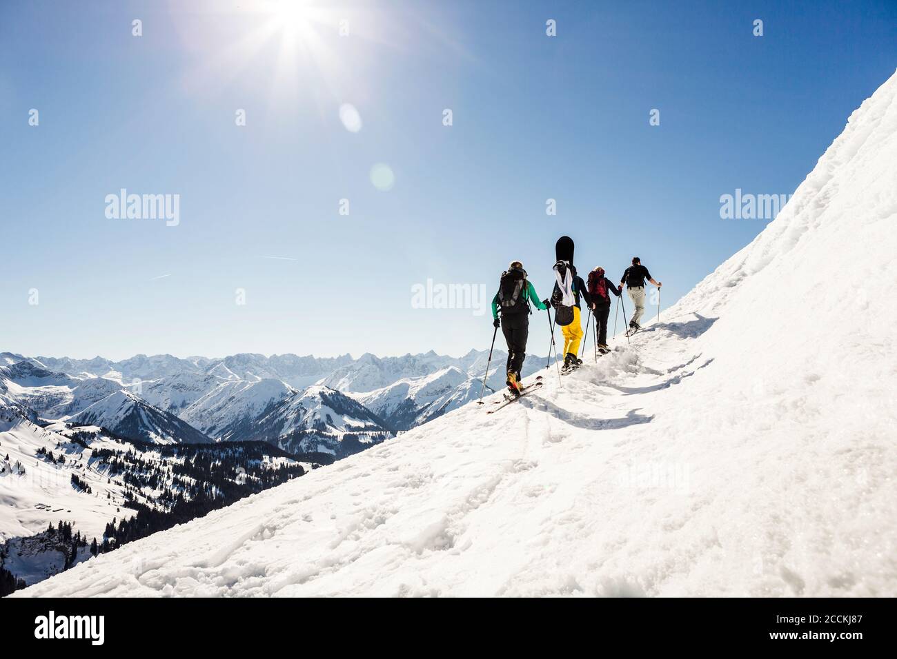 Group of friends ski touring up to a mountain peak, Achenkirch, Austria Stock Photo