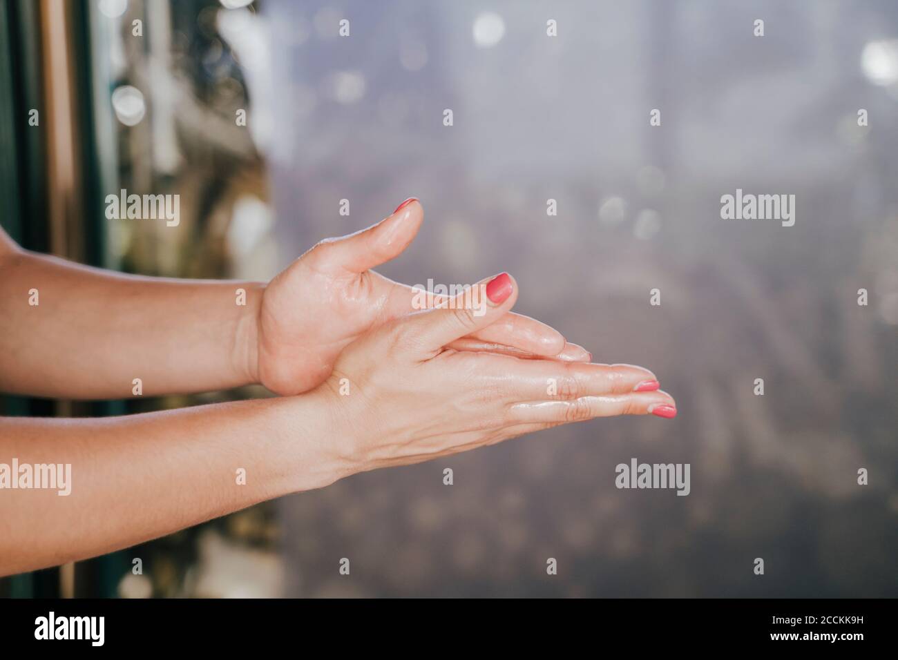 Close-up of female therapist hands with massage oil in spa Stock Photo