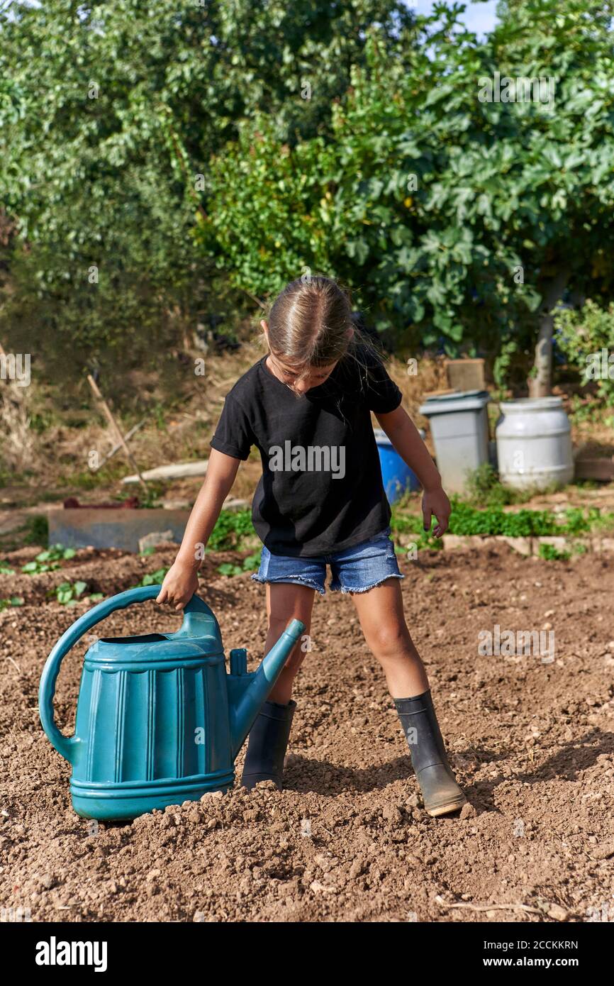 Girl watering with watering can Stock Photo